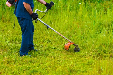 çim adam el ile çim biçme makinesi ile mows