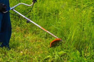 çim adam el ile çim biçme makinesi ile mows