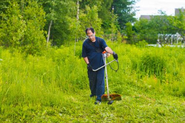 çim adam el ile çim biçme makinesi ile mows
