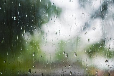 üstünde belgili tanımlık pencere cam yaz aylarında yağmur damlaları