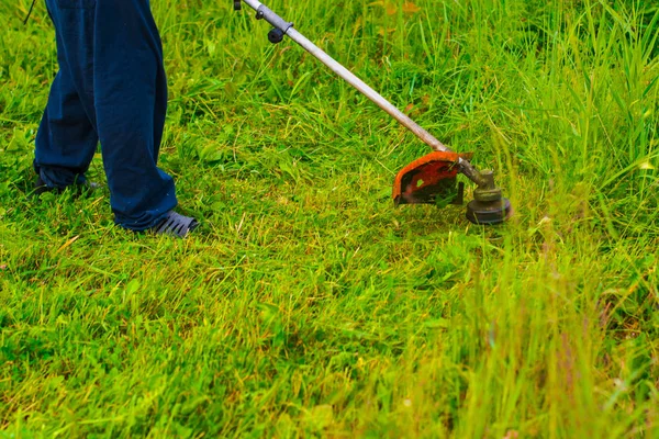 人工割草机割草坪的男子 — 图库照片