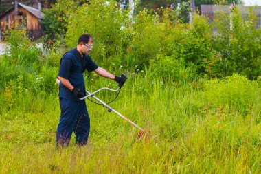 çim adam el ile çim biçme makinesi ile mows