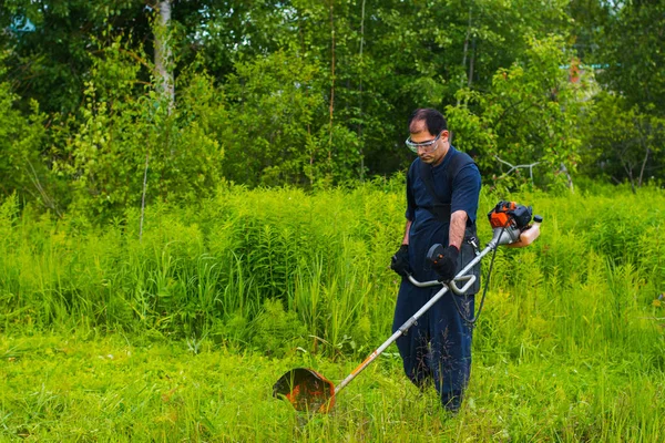 çim adam el ile çim biçme makinesi ile mows
