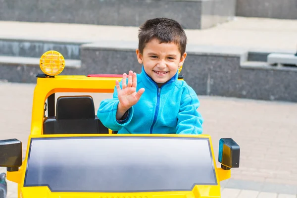 Брюнетка Мальчик Ездит Электрический Желтый Автомобиль Парке — стоковое фото
