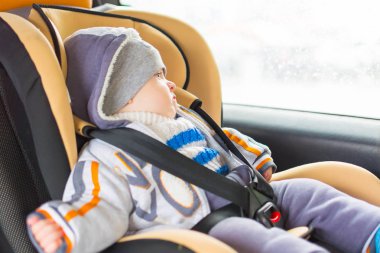 güvenli bir sandalyede tutturulmuş arabada oturan bebek