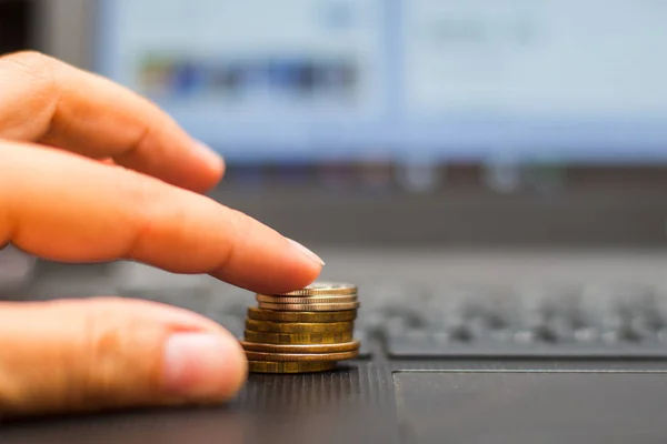 Hand Und Ein Stapel Münzen Auf Einem Laptop — Stockfoto