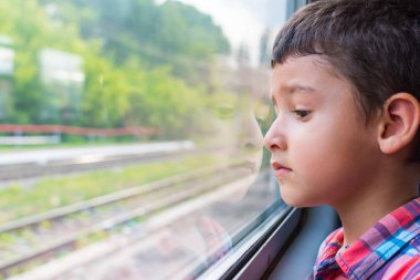 Üzgün çocuk bir tren sürmek ve pencereden görünüyor