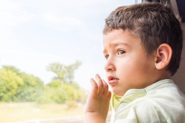 Çocuk 5 yaşında trende pencereden dışarı bakarak ilgi ile