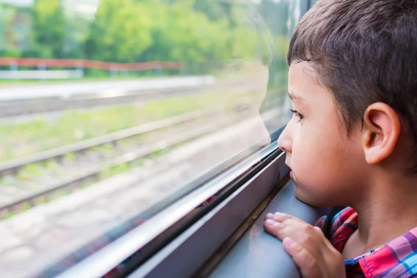 Üzgün çocuk bir tren sürmek ve pencereden görünüyor