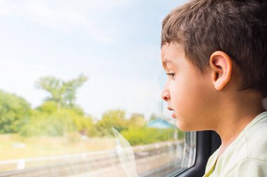 Çocuk 5 yaşında trende pencereden dışarı bakarak ilgi ile