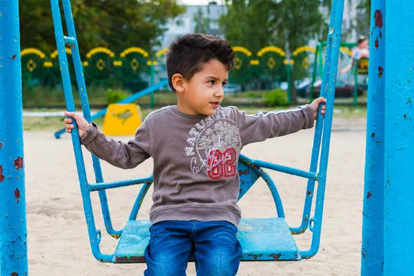 Dunkelhaariger Junge Schwingt Auf Einer Schaukel — Stockfoto