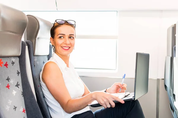鉄道で働くラップトップで笑顔のビジネス女性 — ストック写真