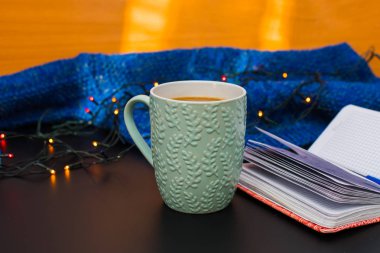 Defter ve çelenk ve kazak çevrili kupa