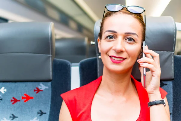 電車の中で携帯電話を持つ若いビジネス女性 — ストック写真