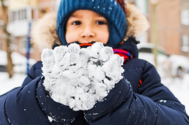 Çocuk eldivenleri karda gösterir. Kış yürüyüş