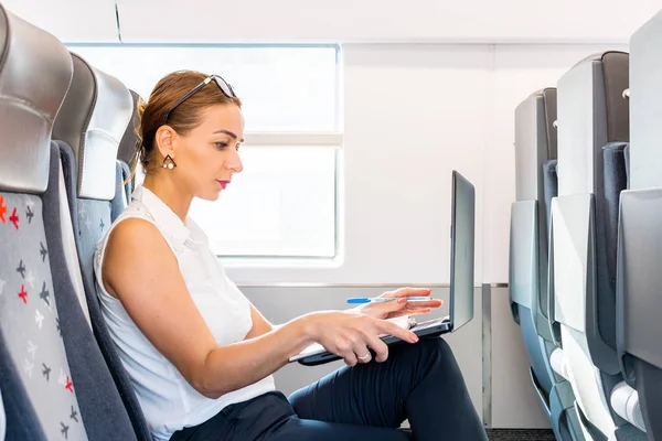 商务女自由职业者在火车上与笔记本电脑工作 — 图库照片