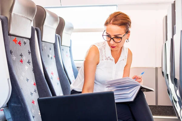 電車でノート パソコンの使用眼鏡を掛けた若いビジネス女性 — ストック写真