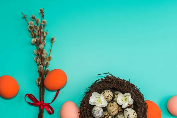 Покрашенные яйца и перепелиные яйца в гнезде с ивовыми ветвями на — стоковое фото