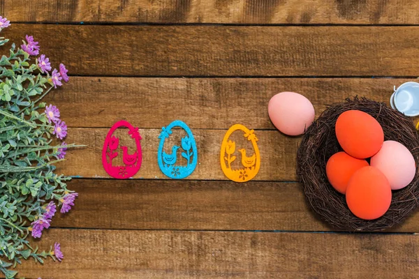 幸せなイースターの組成物。着色された卵と木製バックの花 — ストック写真