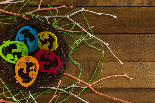 Ziereier im Nest auf Holzgrund. Glückliche Osterkarte. — Stockfoto