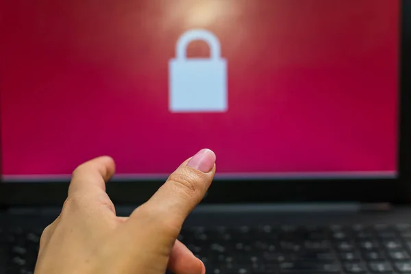 open laptop with a lock on the screen. hand gesture. concept.