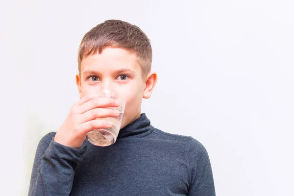 Adolescente chico beber agua de vidrio taza —  Fotos de Stock