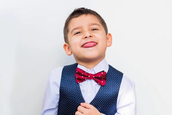 Елегантний хлопчик показує язик на білому тлі — стокове фото