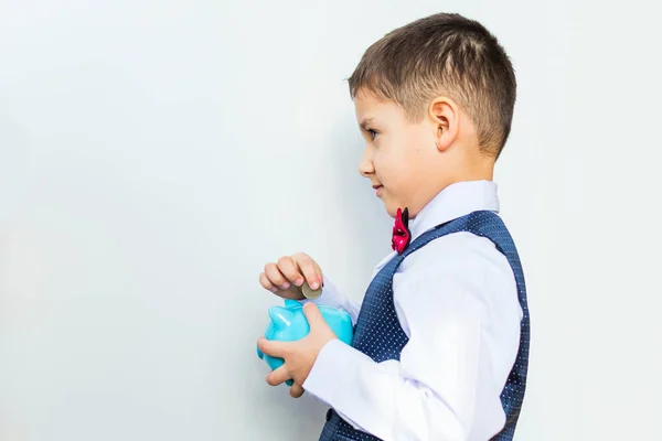 Niño con una alcancía en sus manos sobre un fondo blanco —  Fotos de Stock