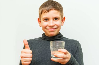 genç çocuk bir bardak su tutan ve Ok jest gösterir