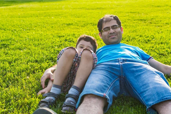 Otec a syn leží v létě na trávě — Stock fotografie