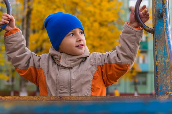 Pojke som leker på lekplatsen under hösten — Stockfoto