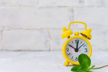 Işık arkaplanı ve yonca üzerindeki sarı alarm saati