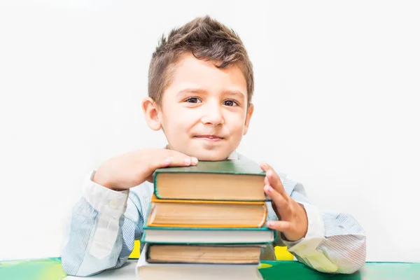 Pojke med böcker sitter vid bordet — Stockfoto