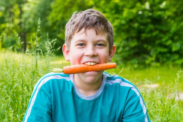 Teen boy w przyrodzie z marchwi — Zdjęcie stockowe