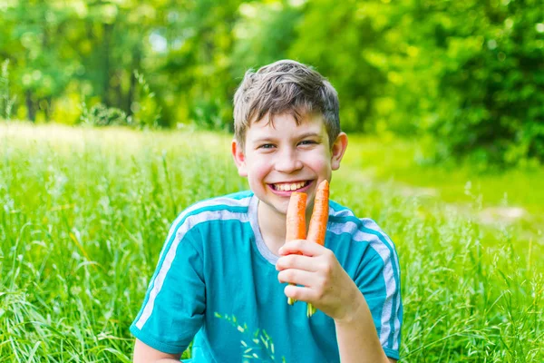 Adolescente con una zanahoria en un bosque —  Fotos de Stock
