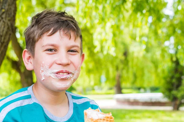 Adolescente chico en el parque comer helado —  Fotos de Stock