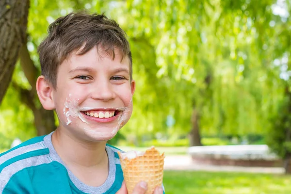 Adolescente chico en el parque comer helado —  Fotos de Stock