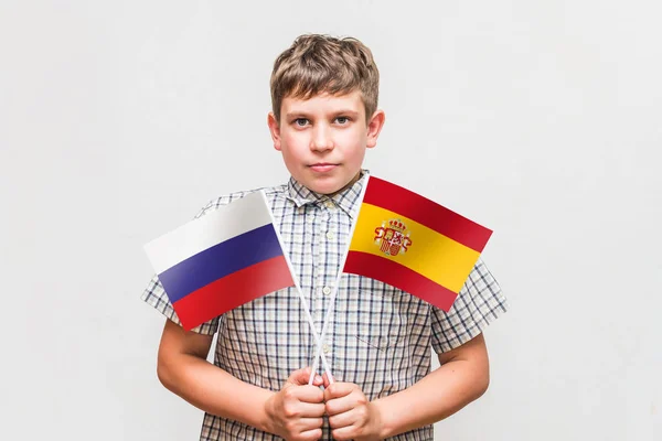 Nastolatek chłopiec trzyma flagi Rosji i Hiszpanii — Zdjęcie stockowe