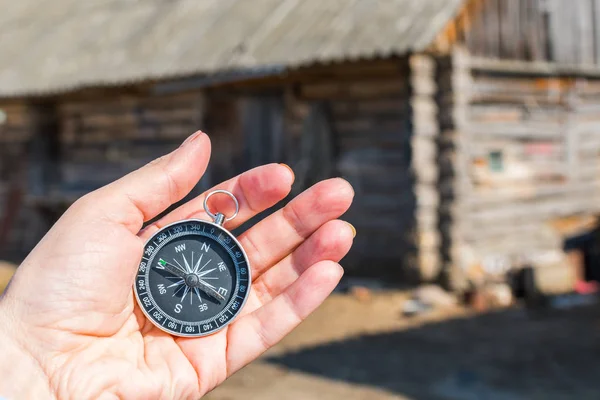 Kompass i handen av en turist på bakgrunden av en trä h — Stockfoto