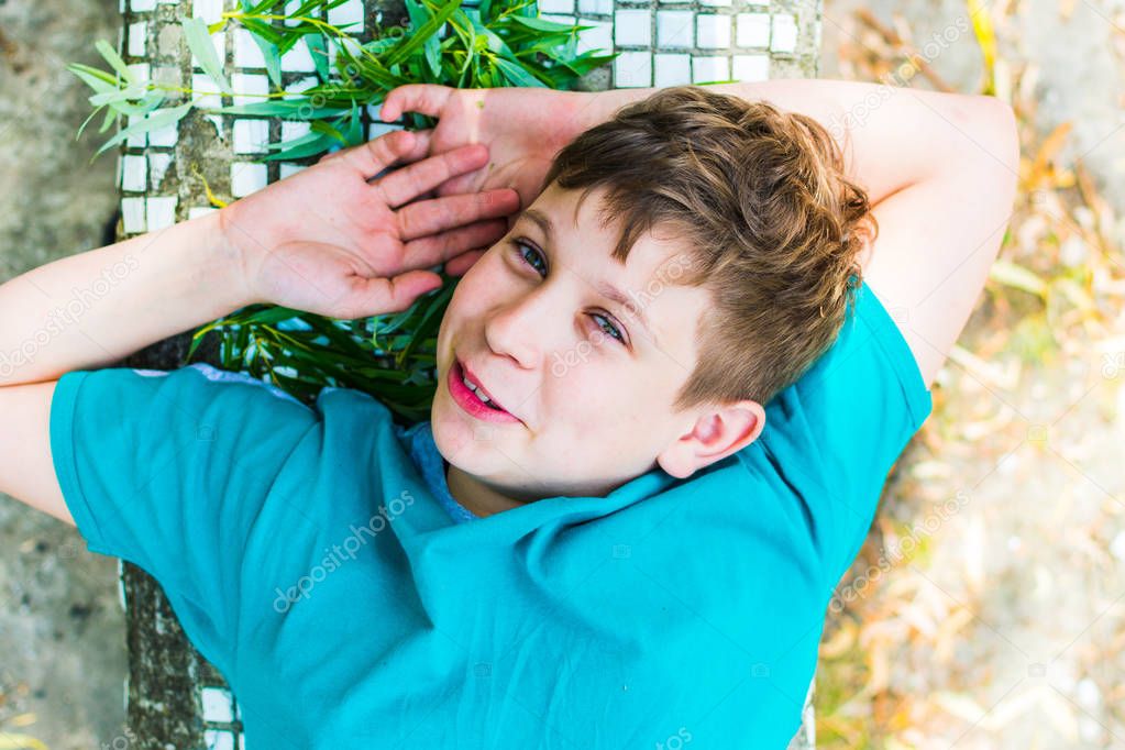 teen boy lies in outdoors. the view from the top