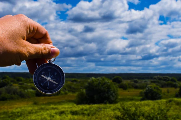 Kompass i hand närbild på bakgrunden av sommaren landskap — Stockfoto