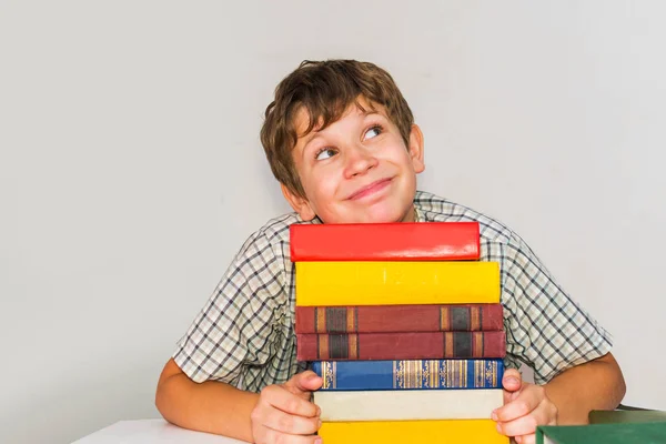 Gelukkige school jongen met boeken op grijze achtergrond — Stockfoto