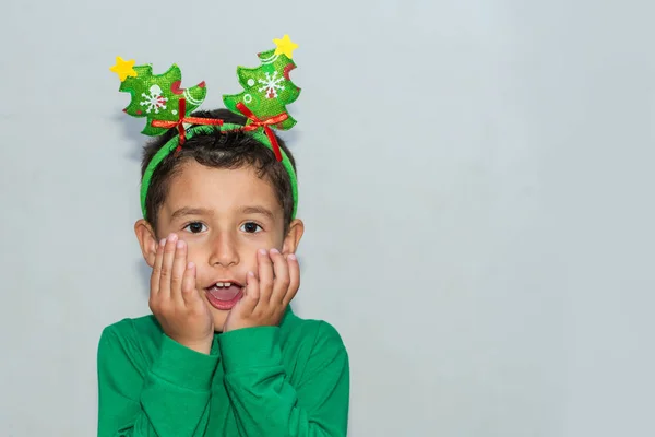 Překvapený chlapec v Christmassym kostýmu na šedém pozadí s poldou — Stock fotografie