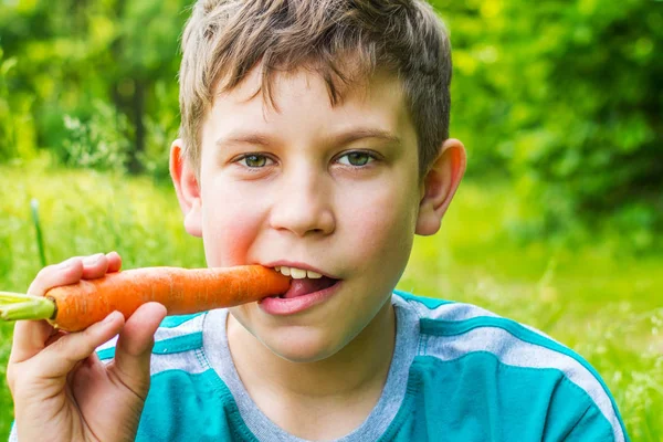 Adolescente chico con zanahoria de cerca —  Fotos de Stock