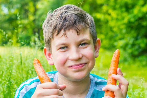 Adolescente chico con zanahoria de cerca —  Fotos de Stock