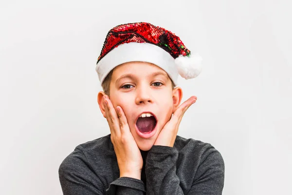 Překvapený chlapec v Santa Hatu na bílém pozadí — Stock fotografie