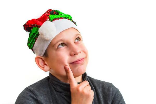 Niño pensativo en sombrero de Santa sobre fondo blanco aislado —  Fotos de Stock