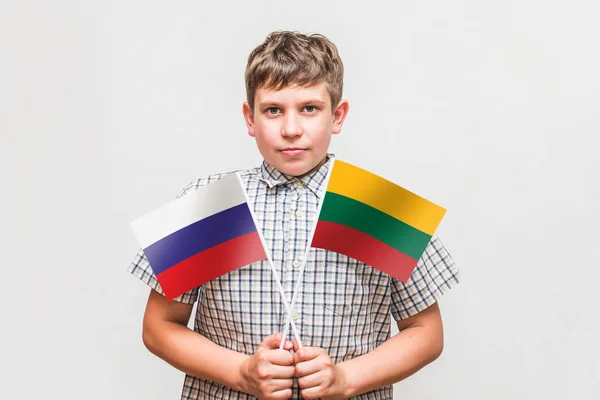 十代の少年はロシアとリトアニアの旗を保持しています — ストック写真