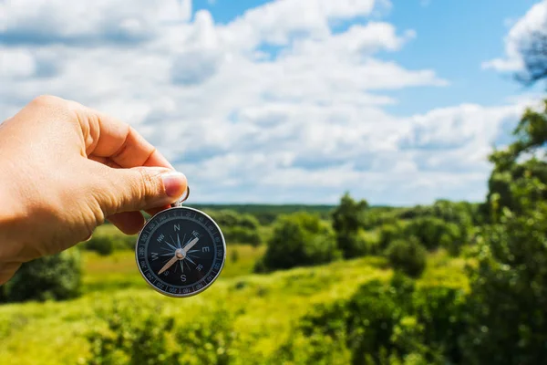 Kompass i hand närbild på bakgrunden av sommaren landskap — Stockfoto