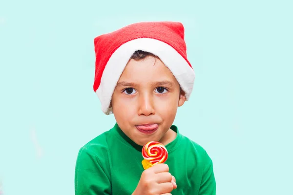 Vtipnej kluk v Santa canově čepici jíst cukroví — Stock fotografie